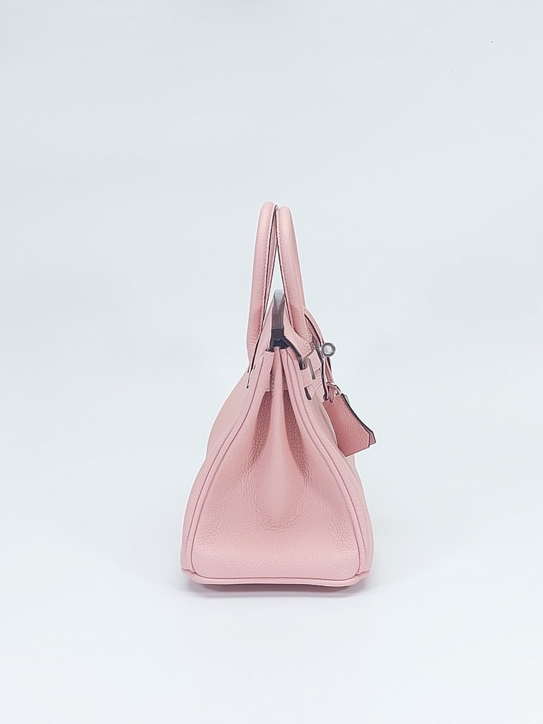 Side view of structured belted top-handle leather bag